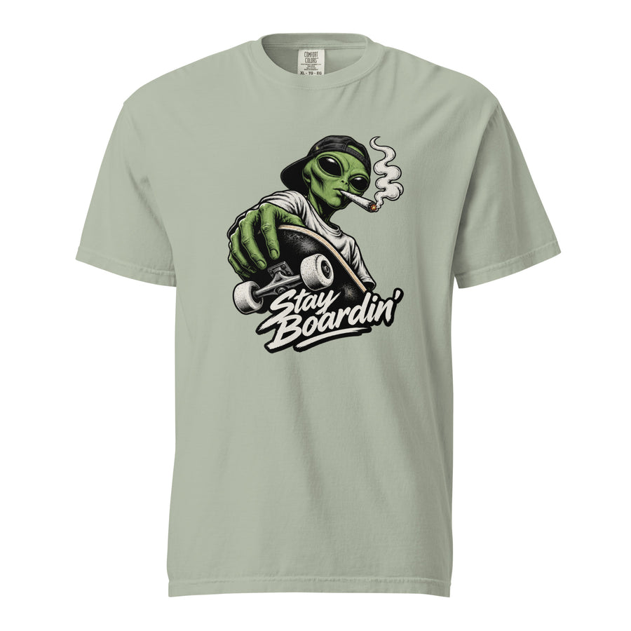Bay T-shirt featuring a green alien in a backwards cap riding a skateboard and smoking above “Stay Boardin’” lettering.
