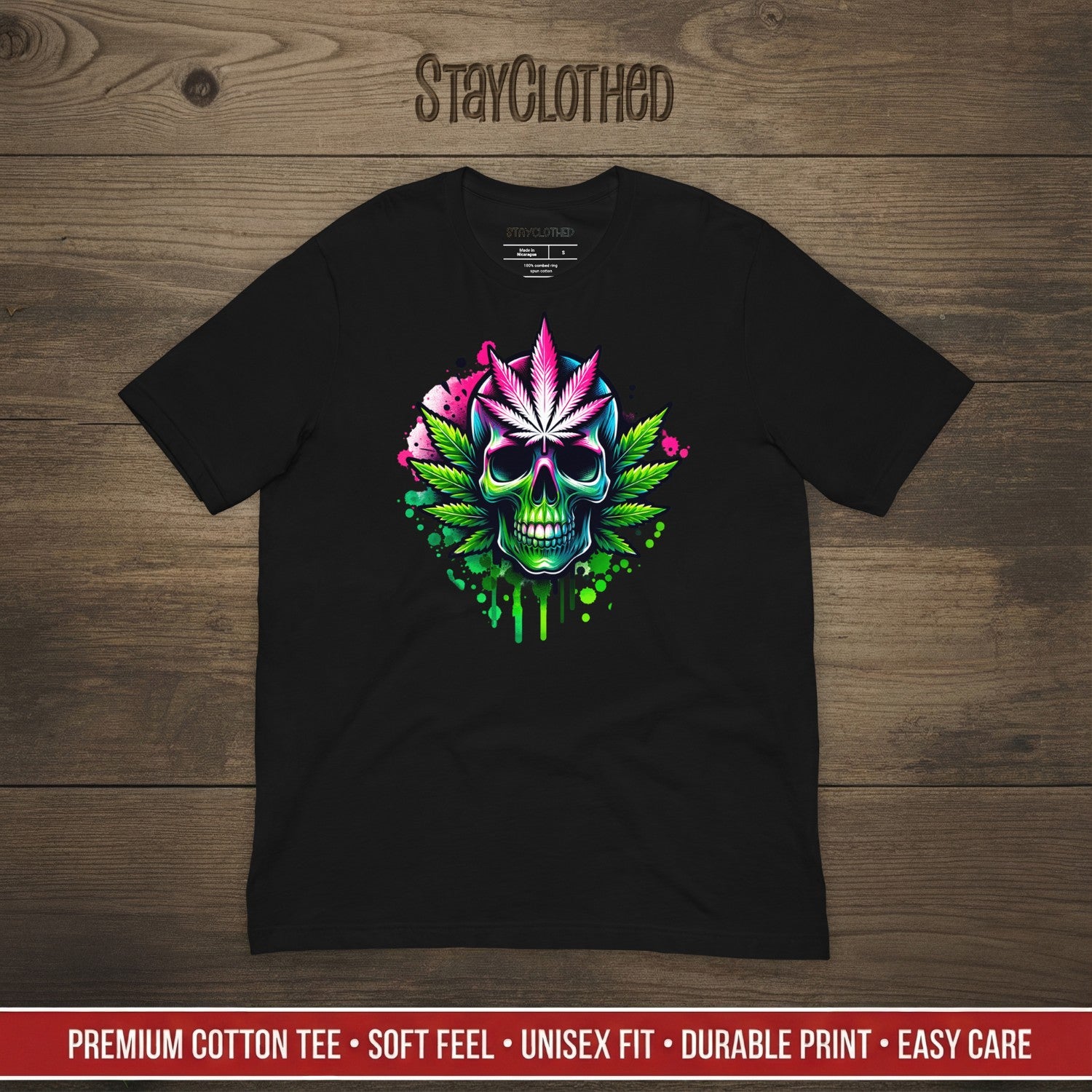 Black t-shirt with colorful skull and cannabis leaf design on a wooden surface, featuring the brand 'StayClothed'.