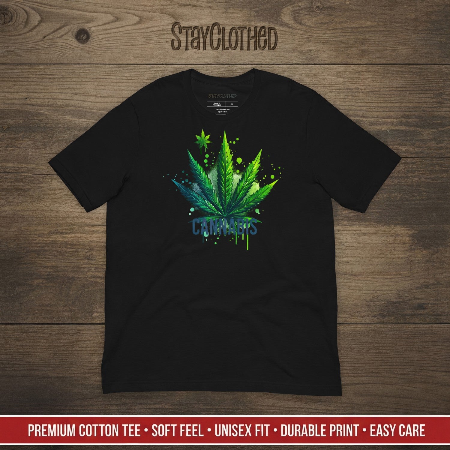Black t-shirt with cannabis leaf design on a wooden surface, featuring the brand 'StayClothed'.