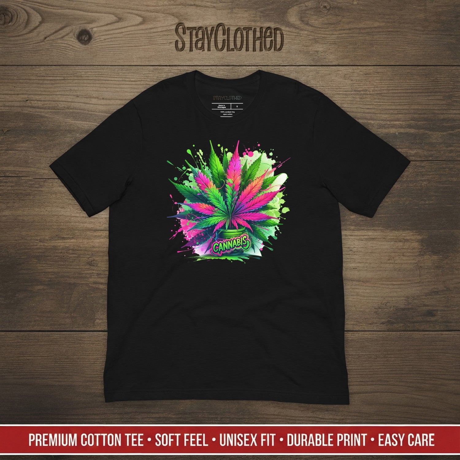 Black t-shirt with colorful cannabis leaf design on a wooden surface, featuring the brand 'StayClothed'.