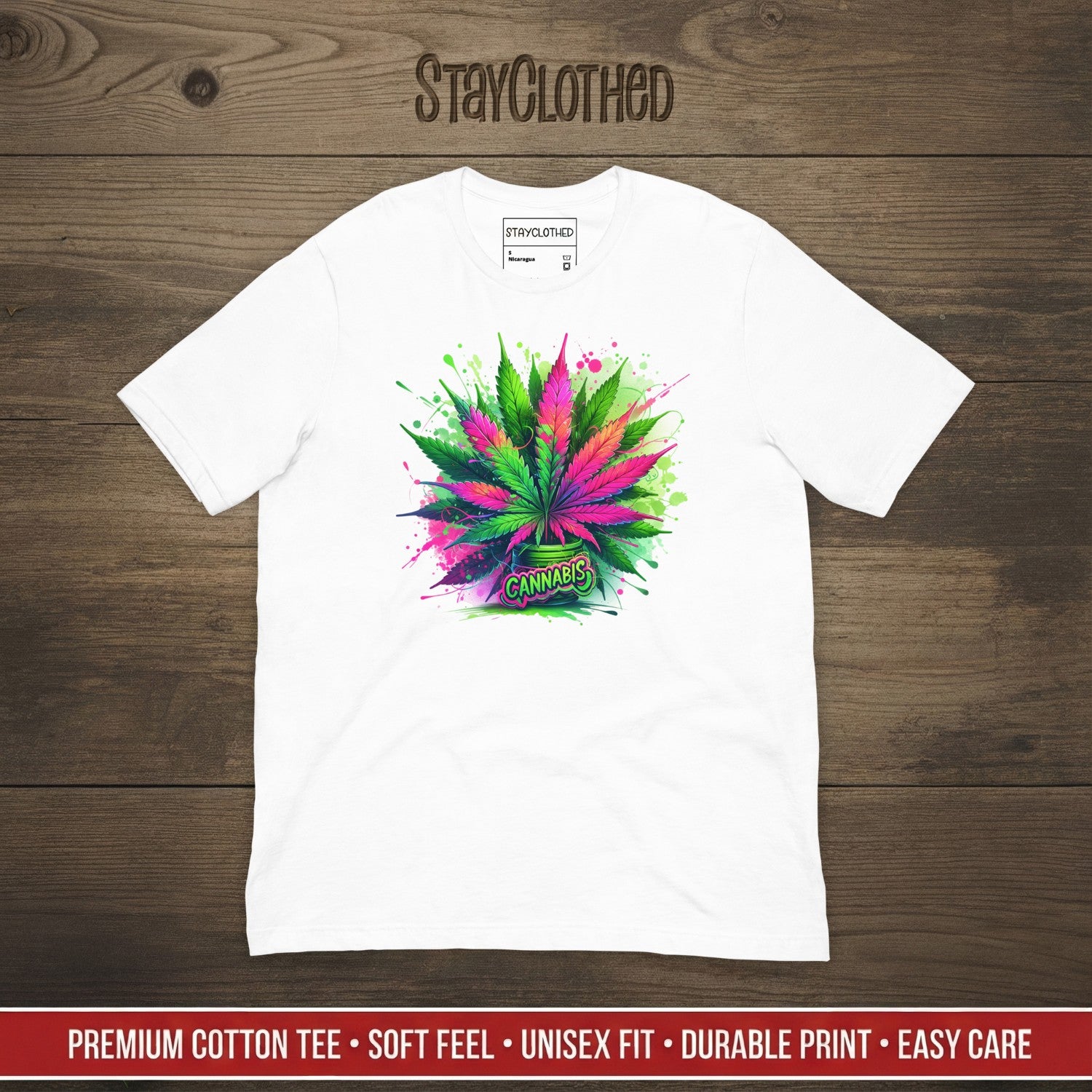 White t-shirt with colorful cannabis leaf design on a wooden surface, featuring 'StayClothed' brand.