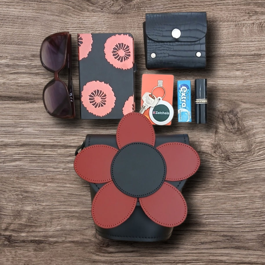 Collection of accessories including a flower-patterned purse, sunglasses, wallet, keys, and lip balm on a wooden surface.