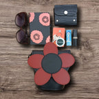 Collection of accessories including a flower-patterned purse, sunglasses, wallet, keys, and lip balm on a wooden surface.