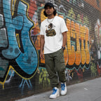 Latino man wearing a white Today I'm Feeling Ambitchous skeleton girl t-shirt in an urban streetwear setting.