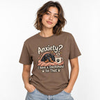 Model wearing an Espresso T-shirt with “Anxiety?” text above a cosy dachshund wrapped in a blanket beside a coffee mug.