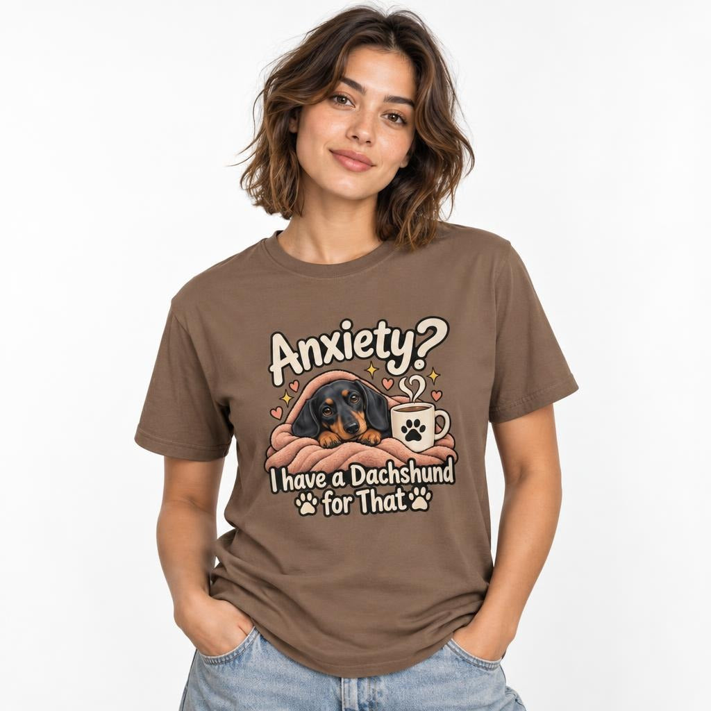 Model wearing an Espresso T-shirt with “Anxiety?” text above a cosy dachshund wrapped in a blanket beside a coffee mug.