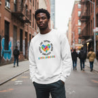 Black man wearing a white autism awareness puzzle heart sweatshirt.
