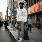 Black man wearing a white autism puzzle piece flag sweatshirt.