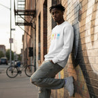 Black man wearing a white autism periodic table sweatshirt.