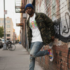 Black man wearing a white autism awareness t-shirt in a streetwear style.