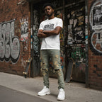 Black man in a streetwear style photo wearing a white t-shirt.
