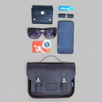 Collection of items including a black leather satchel, sunglasses, phone, wallet, and card on a gray background.