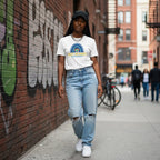 Black woman wearing a white Be Kind autism awareness t-shirt.