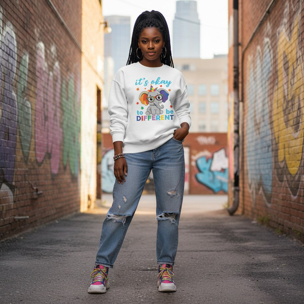 Black woman wearing a white It's Okay To Be Different autism awareness elephant sweatshirt.