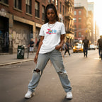 Black woman wearing a white "Love Needs No Words" autism awareness t-shirt.