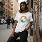 Black woman wearing a white retro sunset puzzle autism awareness t-shirt.