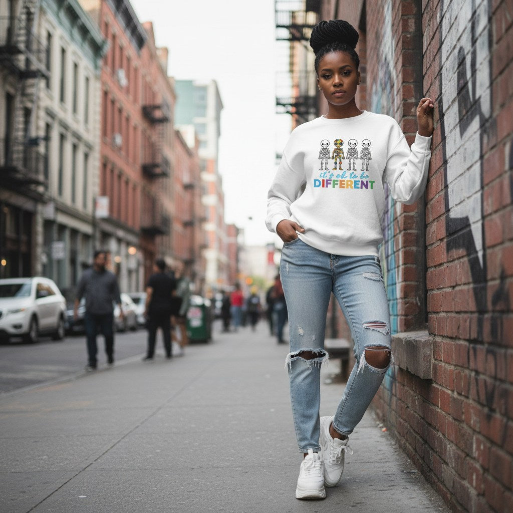 Black woman wearing a white autism skeleton puzzle sweatshirt.
