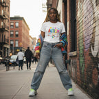 Black woman wearing a white autism awareness T-shirt in a streetwear style.