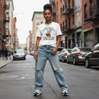 Lifestyle shot of a black woman in streetwear clothing leaning against a wall outdoors