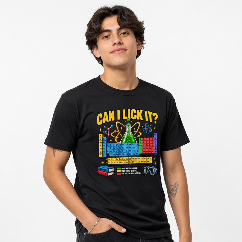 Front view of a person wearing a black T-shirt with “CAN I LICK IT?” above a colourful periodic table, chemistry flask, and atom artwork.