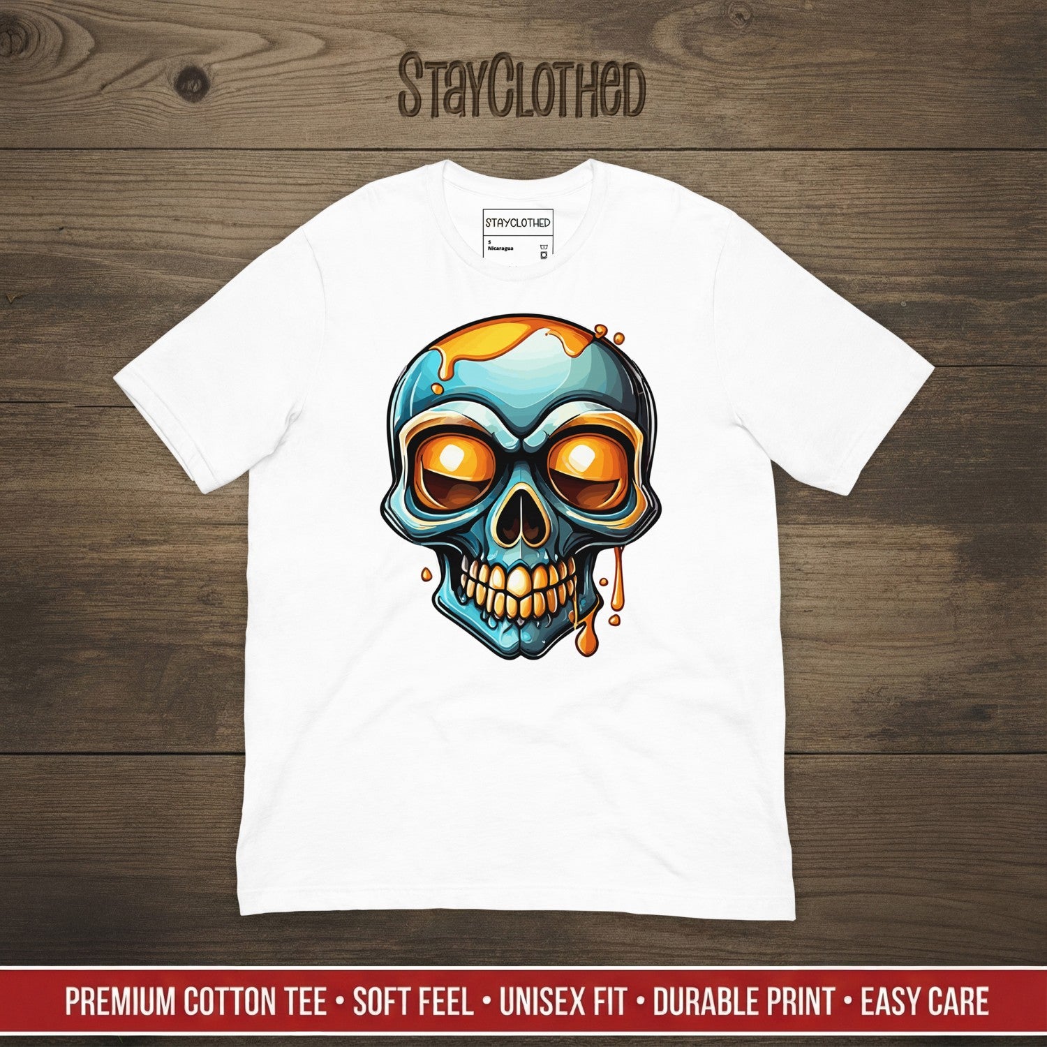 White t-shirt with a colorful skull design on a wooden surface, featuring the brand 'StayClothed'.