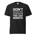 Black T-shirt with bold stacked slogan reading “DON’T RUSH ME / I’M WAITING FOR THE LAST MINUTE” in white and grey lettering.