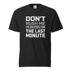 Black T-shirt with bold stacked slogan reading “DON’T RUSH ME / I’M WAITING FOR THE LAST MINUTE” in white and grey lettering.