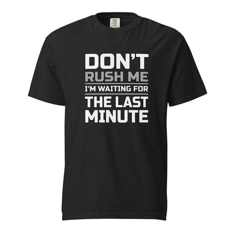 Black T-shirt with bold stacked slogan reading “DON’T RUSH ME / I’M WAITING FOR THE LAST MINUTE” in white and grey lettering.