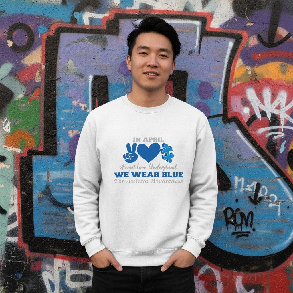East Asian man wearing a white In April We Wear Blue autism awareness sweatshirt.