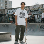 East Asian man wearing a white t-shirt in an urban streetwear setting