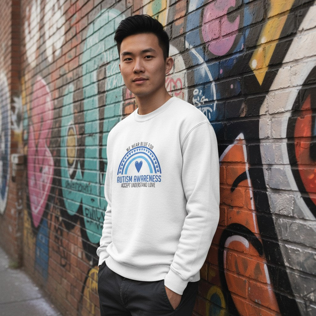 East Asian man wearing a white "We Wear Blue" autism awareness sweatshirt.