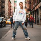 East Asian non-binary person wearing a white "Celebrate Minds of All Kinds" floral heart sweatshirt.