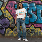 East Asian woman wearing a white autism awareness T-shirt.