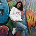 East Asian woman wearing a white autism awareness puzzle heart sweatshirt.