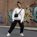 East Asian woman wearing a white autism puzzle piece flag sweatshirt.