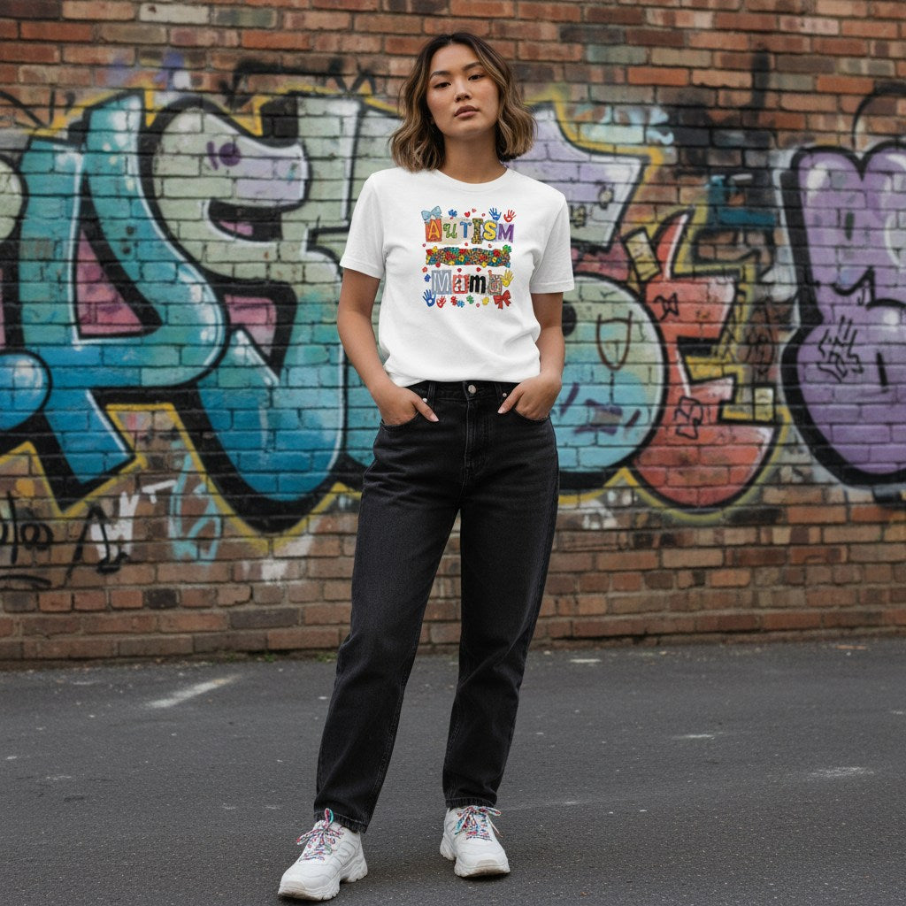 East Asian woman wearing a white autism mama collage t-shirt.