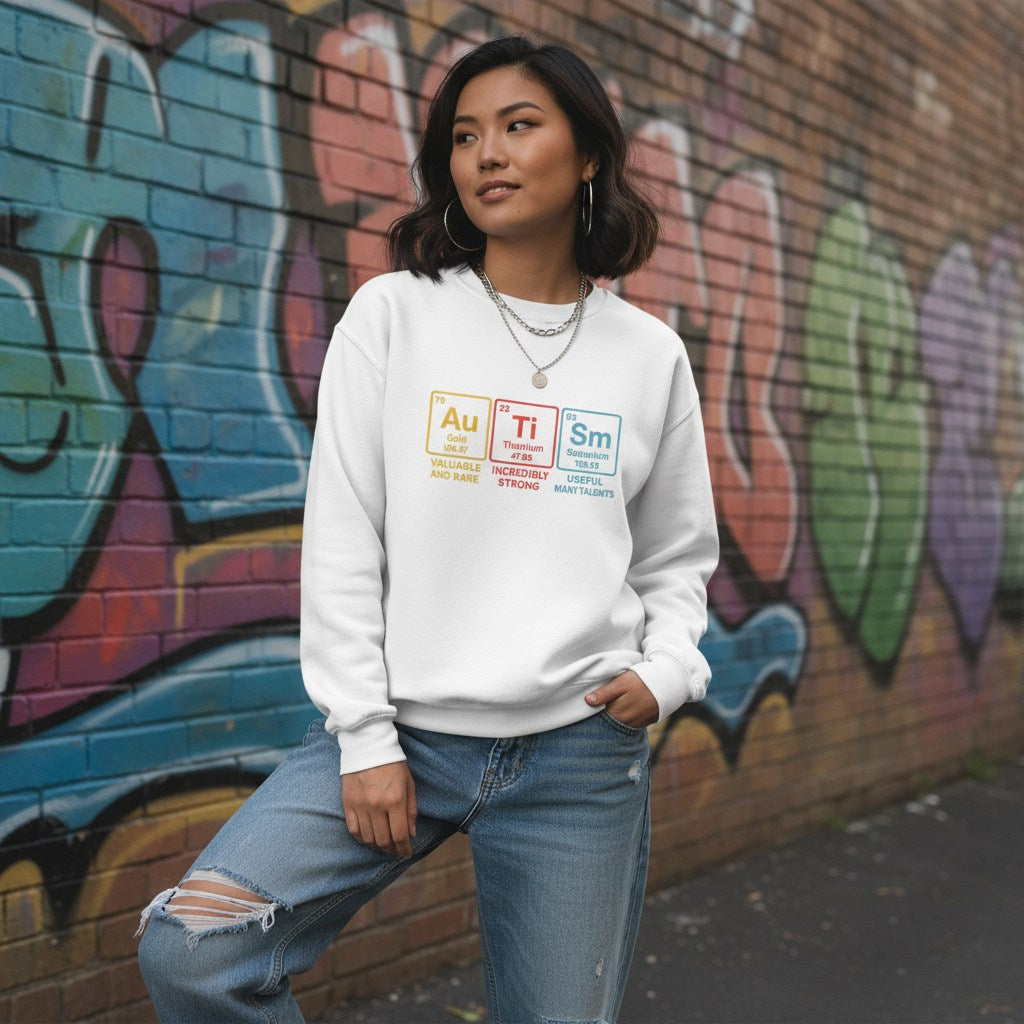 East Asian woman wearing a white autism periodic table sweatshirt.