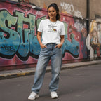 East Asian woman wearing a white His Fight Is My Fight autism solidarity t-shirt.