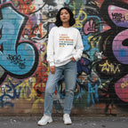 East Asian woman wearing a white I Don't Struggle With Autism sweatshirt.