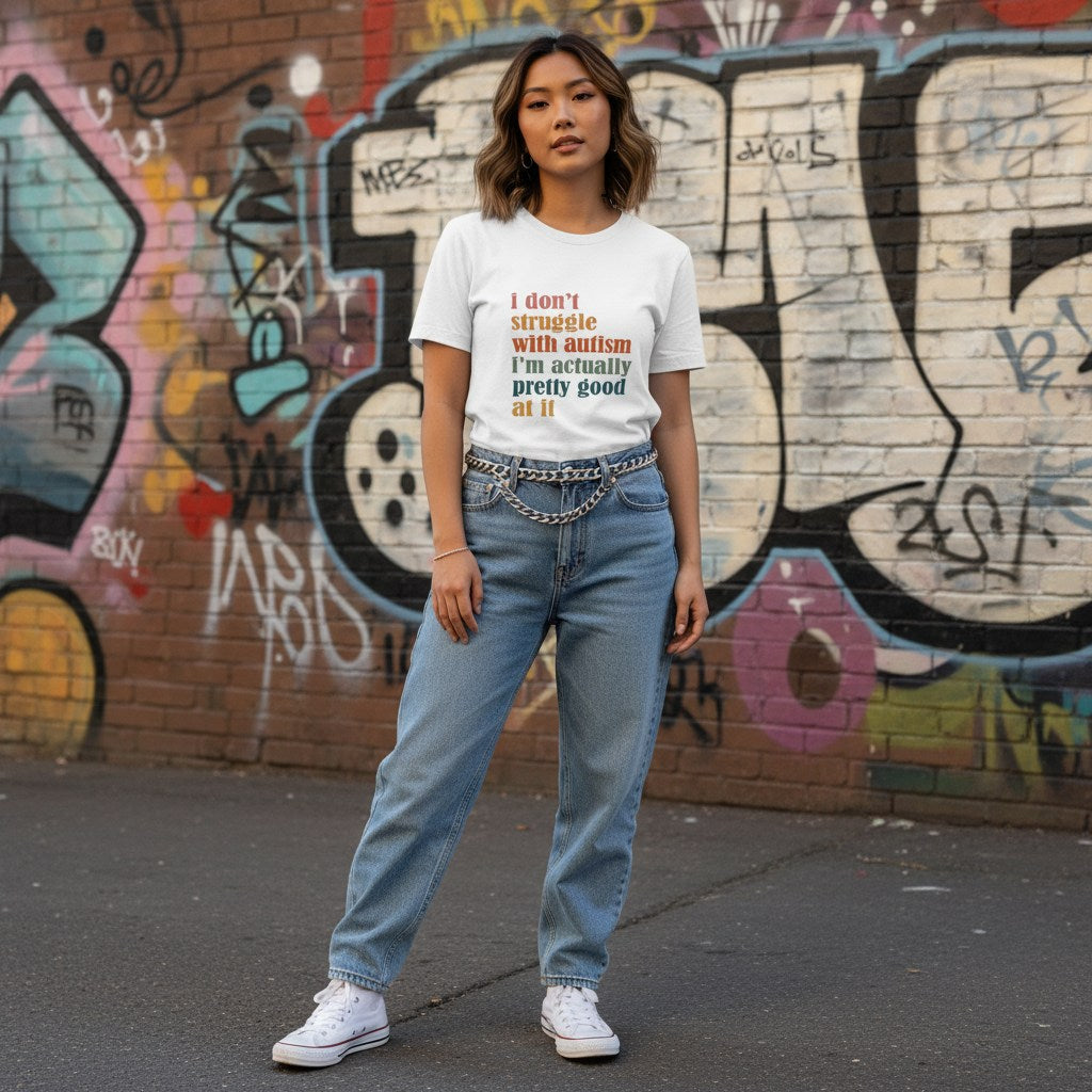 East Asian woman wearing a white I Don't Struggle With Autism I'm Pretty Good At It T-shirt.
