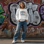 East Asian woman wearing a white autism awareness sweatshirt.