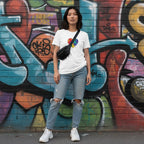 East Asian woman wearing a white rainbow puzzle piece heart t-shirt.