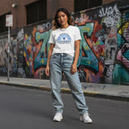 East Asian woman wearing a white autism awareness t-shirt.