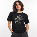 Model wearing a Black T-shirt with a central skull graphic, exposed teeth, and elongated dripping black bone-like forms.