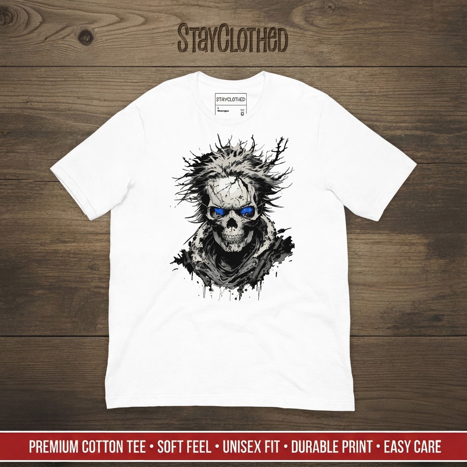 White t-shirt with a skull design on a wooden surface, featuring the brand 'StayClothed'.