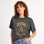 I Ve Survived Too Many Storms Funny Raccoon t shirt in Pepper worn by a studio model in an upper-body three quarter right pose on a clean white background