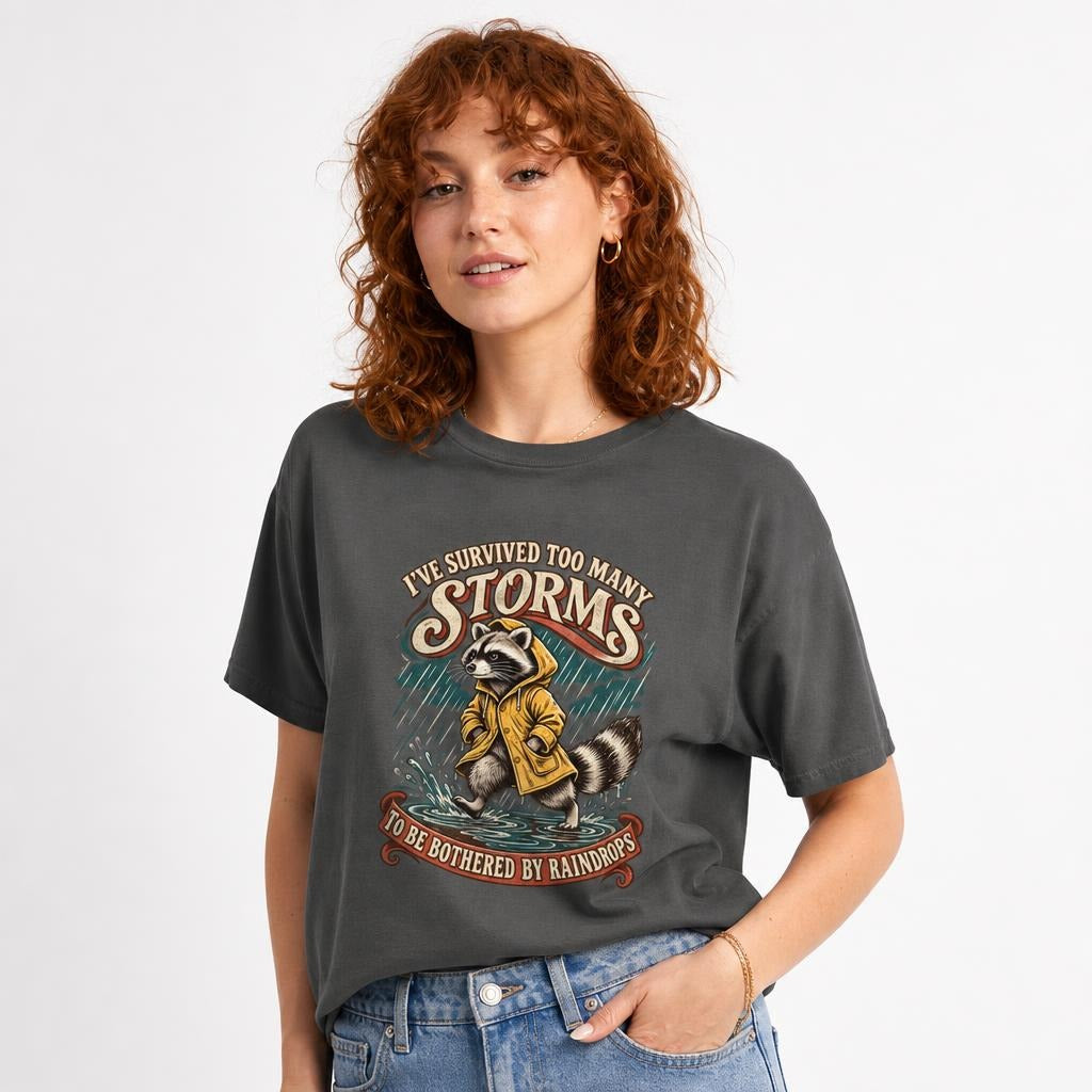 I Ve Survived Too Many Storms Funny Raccoon t shirt in Pepper worn by a studio model in an upper-body three quarter right pose on a clean white background