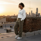 Latina woman wearing a white autism periodic table sweatshirt.