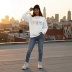 Latina woman wearing a white autism periodic table sweatshirt.