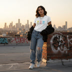 Latina woman wearing a white autism periodic table T-shirt.